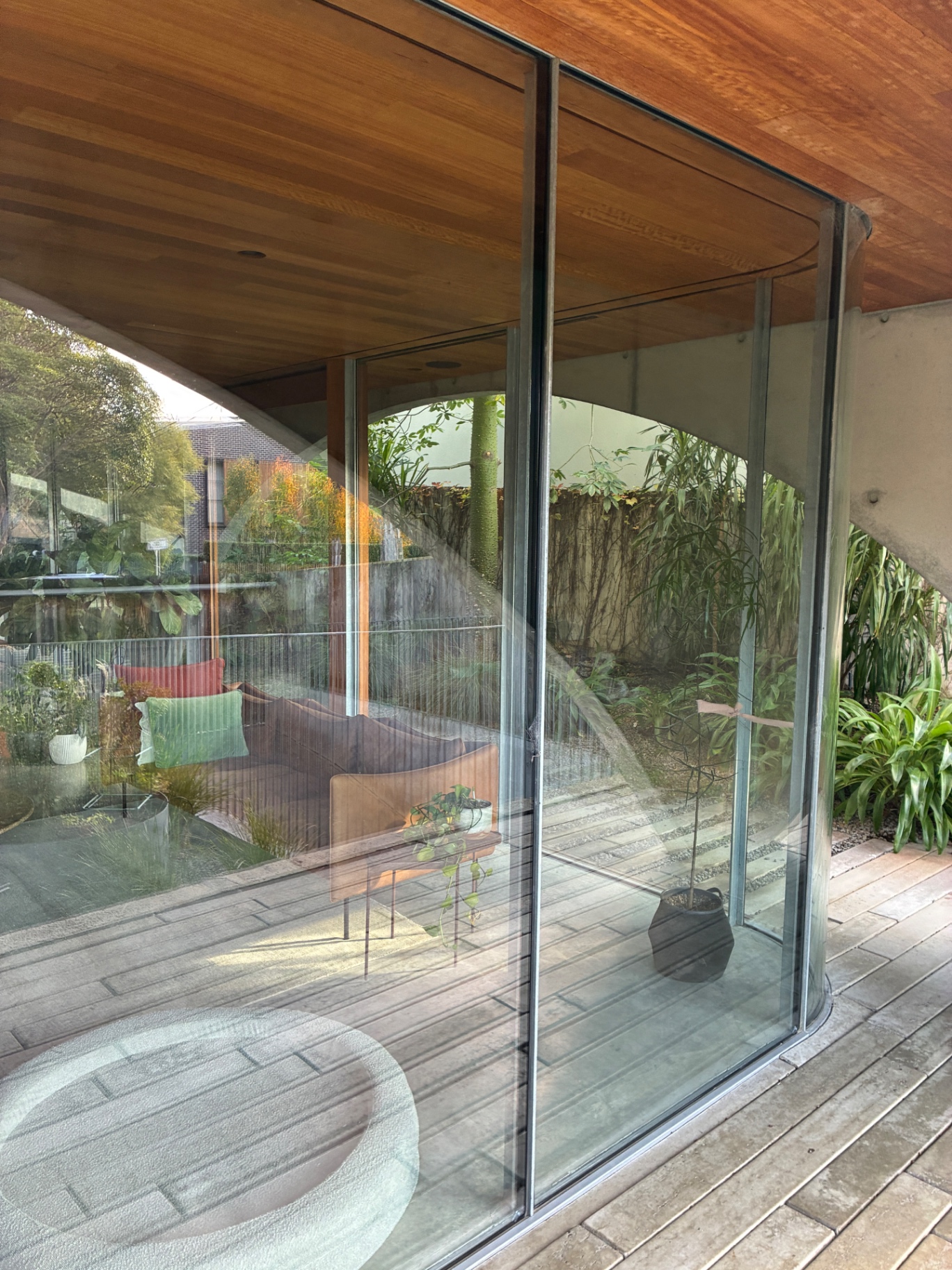 Curved glass slider cleaned under the timber-lined ceiling in Hawthorn House in Hawthorn East, Victoria — Bluewater Pressure Washing